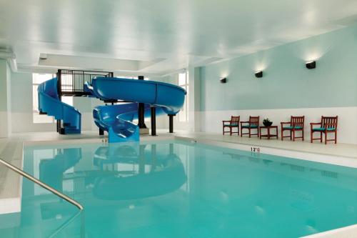 a swimming pool with a blue water slide at Radisson Hotel & Conference Centre Calgary Airport in Calgary