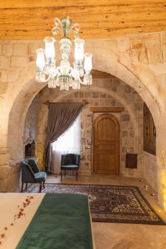 a large room with a chandelier and a stone wall at Solo Cave Suites in Nevsehir