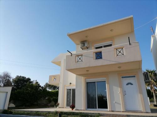 a large white house with a blue sky at Katerina Villa In Kiotari in Kiotari
