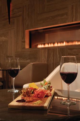 a table with a plate of food and two glasses of wine at Radisson Hotel & Conference Centre Calgary Airport in Calgary