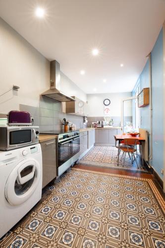 une cuisine avec un lave-linge et une table. dans l'établissement Maison du jardin botanique 7 min centre et Gare, à Tourcoing