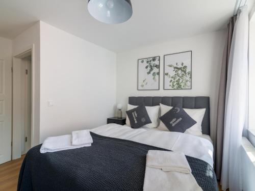 a bedroom with a large bed with black and white pillows at Limehome Bayreuth Spitalgasse in Bayreuth