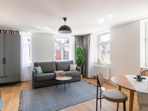 a living room with a couch and a table at limehome Bayreuth Spitalgasse in Bayreuth