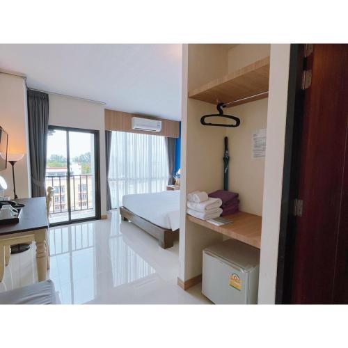 a hotel room with a bed and a desk at The Sixteenth Naiyang Beach Hotel- Free Schedule Airport Shuttle in Nai Yang Beach