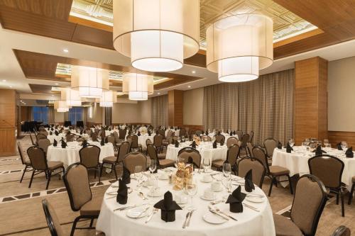 a banquet hall with white tables and chairs and chandeliers at Radisson Hotel & Conference Centre Calgary Airport in Calgary