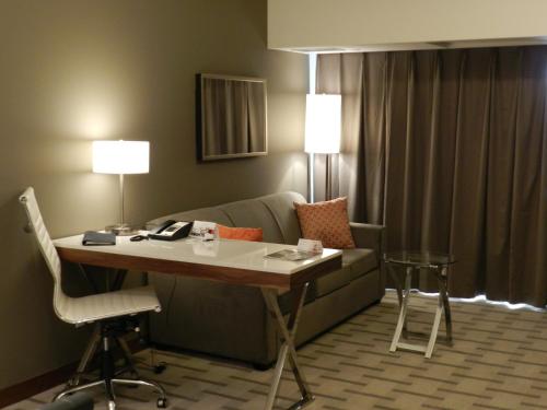 a living room with a couch and a table in a room at Radisson Hotel & Conference Centre Calgary Airport in Calgary