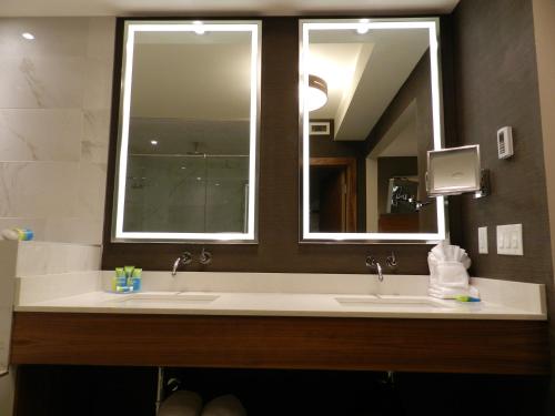 a bathroom with two sinks and a large mirror at Radisson Hotel & Conference Centre Calgary Airport in Calgary