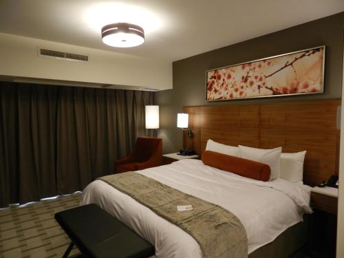 a hotel room with a bed and a desk at Radisson Hotel & Conference Centre Calgary Airport in Calgary