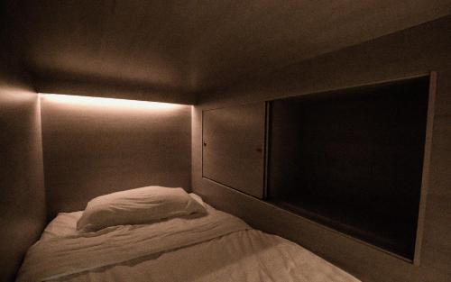 a small bed in a dark room with a light at Amazing Home Inn in George Town