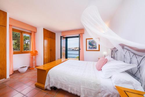 a bedroom with a white bed and a window at Casa Vacacional Es Niu in Portocolom
