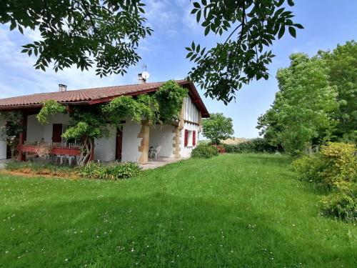 uma casa com um relvado verde em frente em Baketsua em Saint-Pée-sur-Nivelle