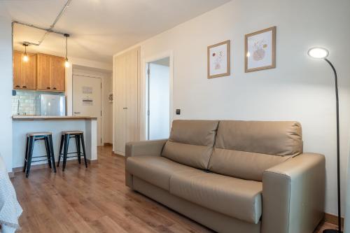 a living room with a couch and a kitchen at Apartamentos Salou - 111 in Salou