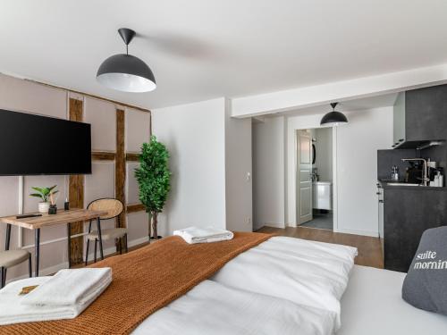 a bedroom with a bed and a table and a kitchen at Limehome Bayreuth Spitalgasse in Bayreuth