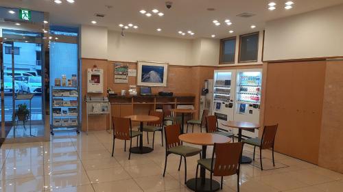 川崎市にある東横INN川崎駅前砂子のテーブルと椅子とカウンターのあるレストラン