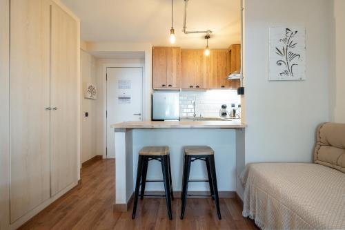 a kitchen with a counter and two stools in a room at Apartamentos Salou - 112 in Salou