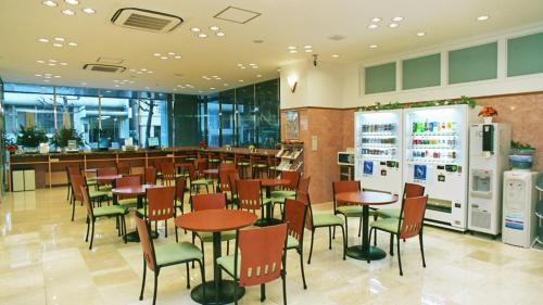 a restaurant with tables and chairs and a bar at Toyoko Inn Yokohama Kannai in Yokohama