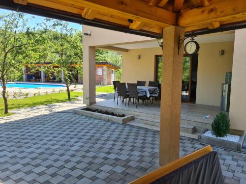 a patio with a clock and a table and chairs at Holiday Home Faruk in Račić