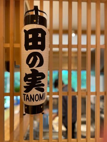 a bottle of tannamon hanging from a fence at ゲストハウス酒坊多満自慢 in Fussa