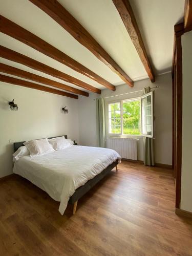 une chambre avec un grand lit et une fenêtre dans l'établissement Baketsua, à Saint-Pée-sur-Nivelle