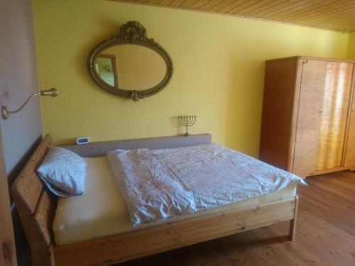 1 dormitorio con 1 cama con espejo en la pared en Ferienwohnung Späth, en Ramsthal