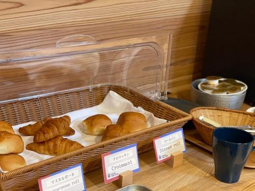 two baskets of pastries sitting on a table with signs at ゲストハウス酒坊多満自慢 in Fussa