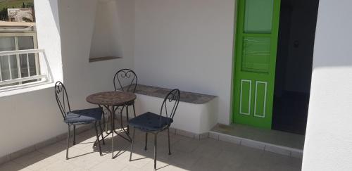 a table and chairs in a room with a green door at Da Luciano in Stromboli