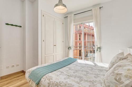 Habitación blanca con cama y ventana en Bright & Breezy MERCED, en Málaga