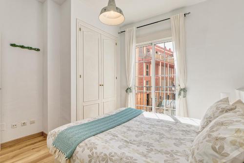 ein weißes Schlafzimmer mit einem Bett und einem Fenster in der Unterkunft Bright & Breezy MERCED in Málaga