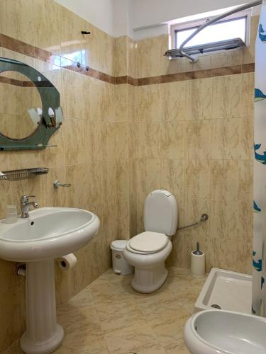 a bathroom with a white toilet and a sink at The First Hotel Saranda in Sarandë