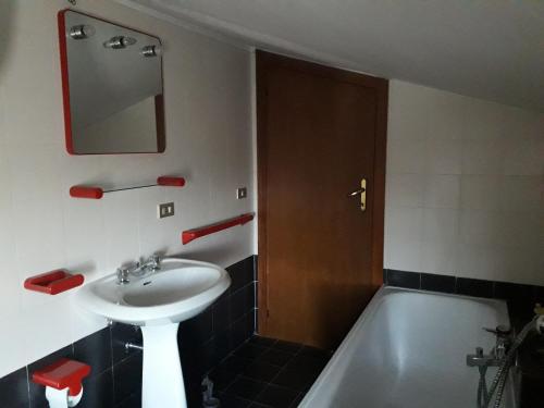 a bathroom with a sink and a tub and a mirror at Villino Sabina in Civitella del Tronto