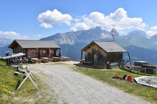 a couple of buildings with mountains in the background at Tgamon Somtgant mit Glasdach in Malmigiuer