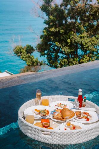 a table with a plate of food and drinks at The Shore At Katathani - Adult Only - SHA Extra Plus in Kata Beach