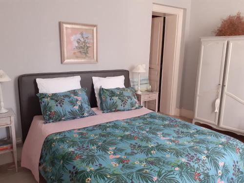 a bedroom with a bed with a blue blanket and pillows at La Fenice Beauval in Saint-Aignan