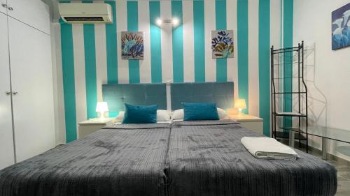 a bedroom with a large bed with blue and white stripes at estudio con vista al mar 19 in Benalmádena