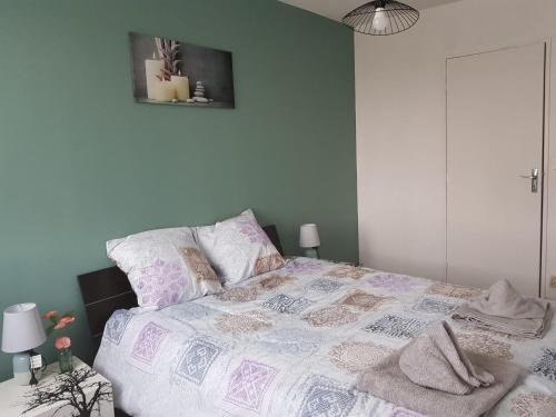 - une chambre avec un lit doté d'une couette violette et blanche dans l'établissement Superbe appartement de 41m2 en résidence privé, à Fleury-les-Aubrais