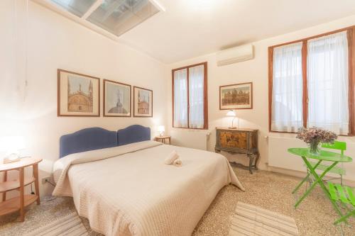 een slaapkamer met een bed en een tafel en ramen bij Canal Grande Suite in Venetië