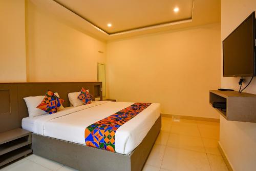 1 dormitorio con 1 cama y TV de pantalla plana en FabHotel Champion Gateway, en Bangalore