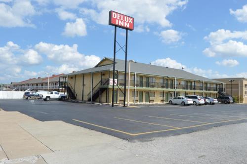 a sign in a parking lot in front of a hotel at Delux Inn Tulsa in Tulsa
