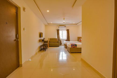 a hotel room with a bed and a living room at FabHotel Champion Gateway - Yelahanka in Bengaluru