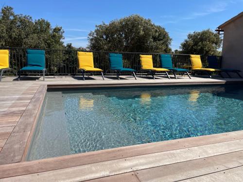 un groupe de chaises assises à côté d'une piscine dans l'établissement CASE DI A CAPPANA-Villa VINCENT, à Bonifacio