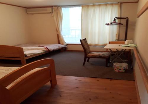 um quarto com um quarto com uma cama e uma secretária em 春日ハウス KasugaHouse em Tsukuba