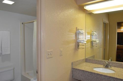 a bathroom with a sink and a mirror at Delux Inn Tulsa in Tulsa