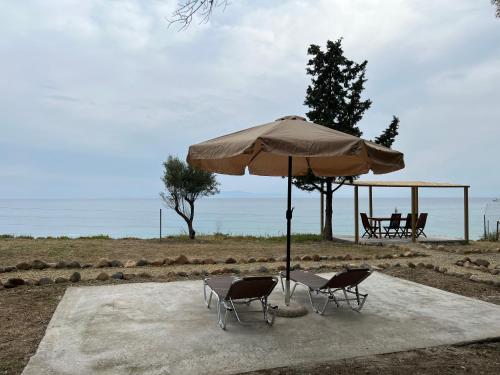 an umbrella and two chairs and a table and chairs at iHouse Nea Skioni in Nea Skioni