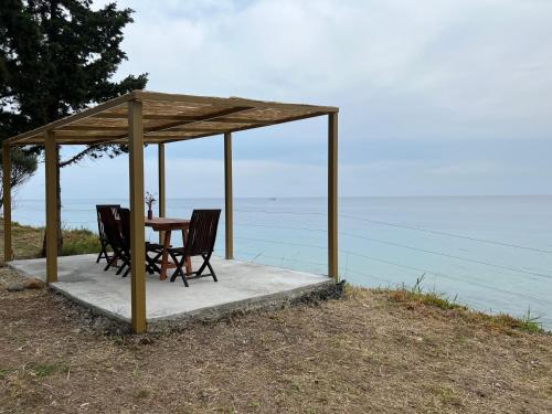 a table and chairs under a gazebo on the beach at iHouse Nea Skioni in Nea Skioni