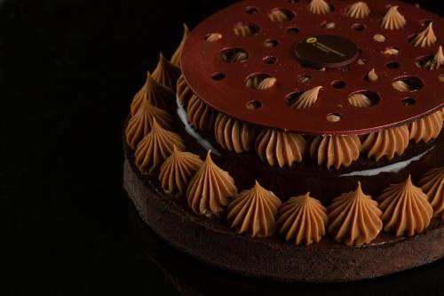 a chocolate cake with orange icing and shells on it at InterContinental Al Khobar by IHG in Al Khobar