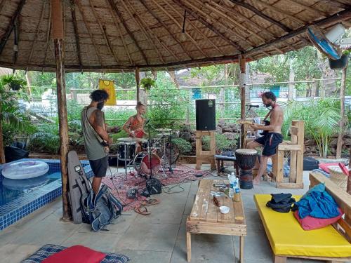 een groep mannen die muziek spelen in een paviljoen bij Red Monkeys Hostel in Arambol
