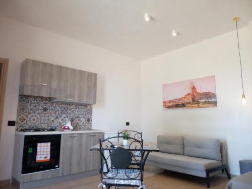 a kitchen with a couch and a table and a stove at Isole Dello Stagnone Apartaments in Birgi Vecchi