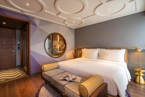 a hotel room with a large bed and a couch at Fusion Original Saigon Centre in Ho Chi Minh City
