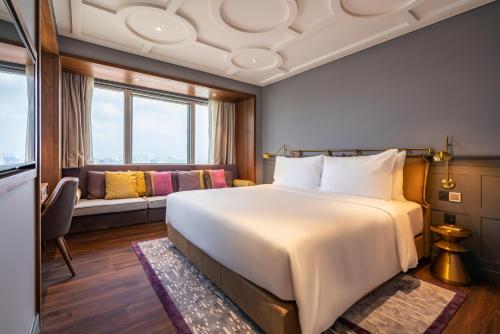 a hotel room with a large bed and a couch at Fusion Original Saigon Centre in Ho Chi Minh City