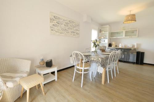 une salle à manger et une cuisine avec une table et des chaises dans l'établissement Une grande maison pour 10 proche de la mer, à Saint-Gilles-Croix-de-Vie